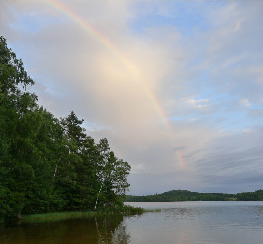 Rainbow reflecting in lake.
